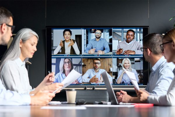 Global corporation online videoconference in meeting room with diverse people sitting in modern office and multicultural multiethnic colleagues on big screen monitor. Business technologies concept.